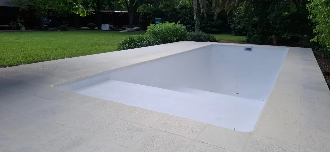 Piscina blanca en jardín