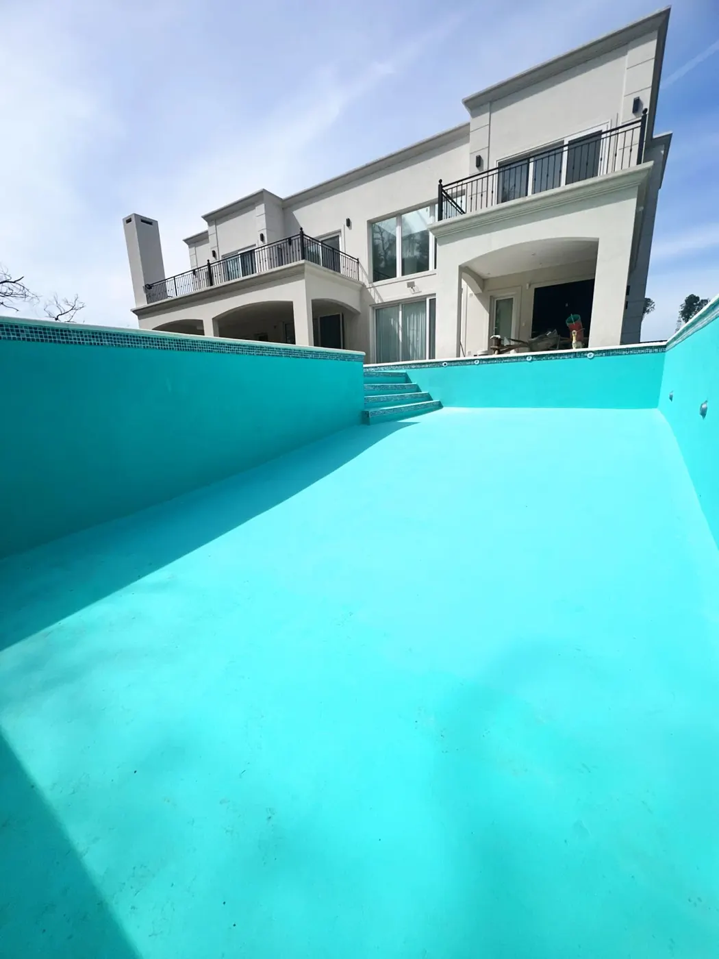 Piscina de hormigón terminada frente a vivienda